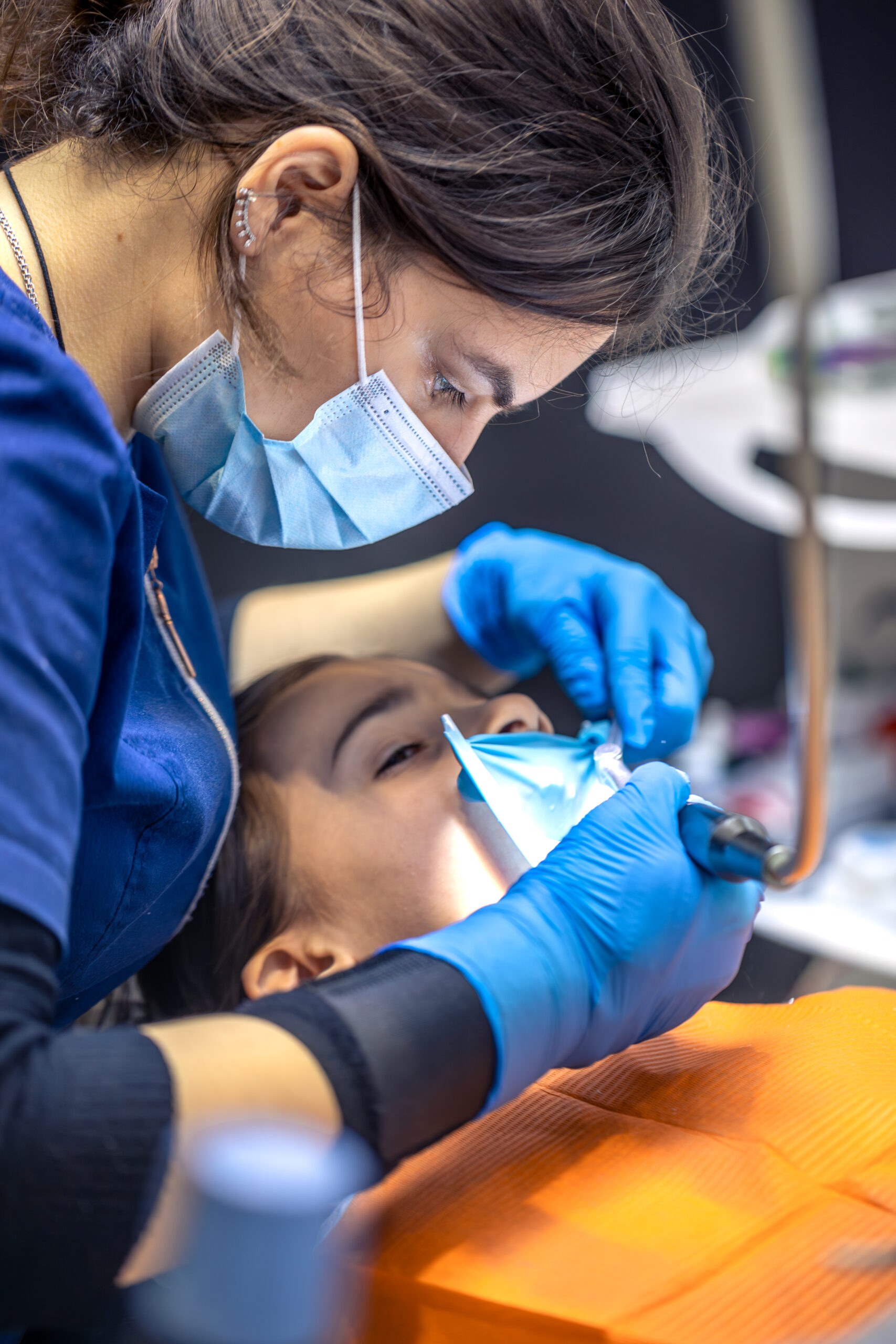 The dentist treats the child's tooth using a rubber dam. Close-up of tooth treatment. dentista trabajando